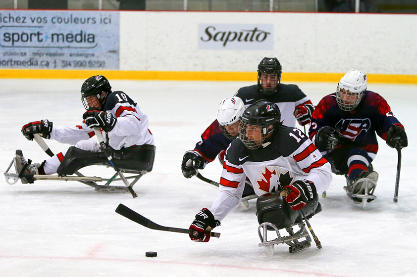 Para hockey players in motion during a game. 
