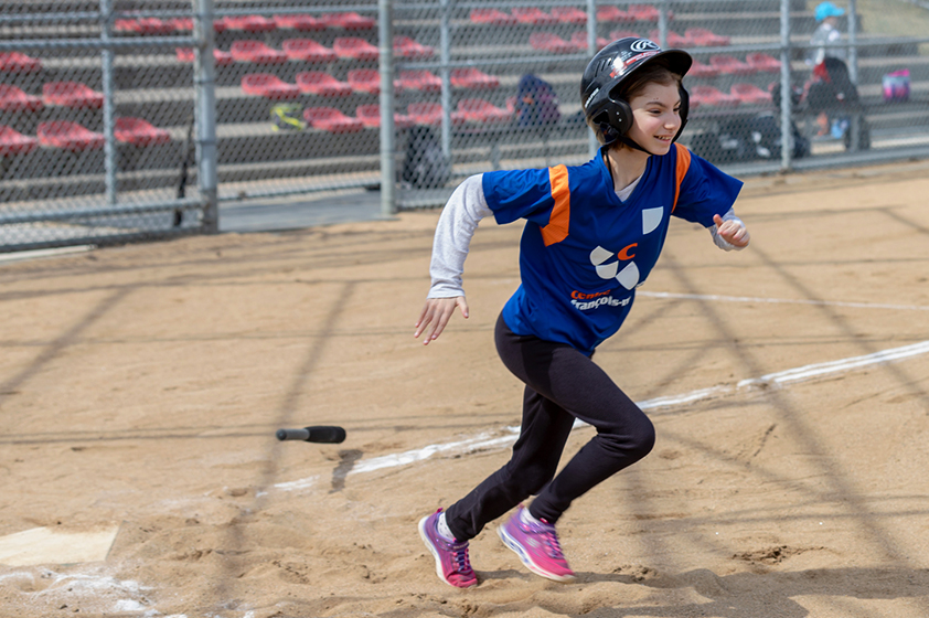 Jeune athlète en action pendant un match de baseball.