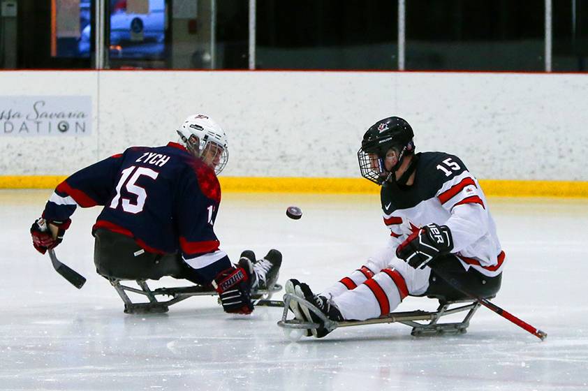 Para hockey athletes in motion during a game. Para hockey athletes in motion during a game.