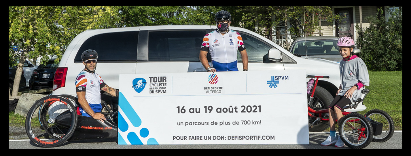 Le paracycliste Patrick Desnoyers, le président directeur-général d'AlterGo et la jeune Emy posent devant un coroplast indiquant les dates du Tour cycliste 2021 : 16 au 19 août 2021