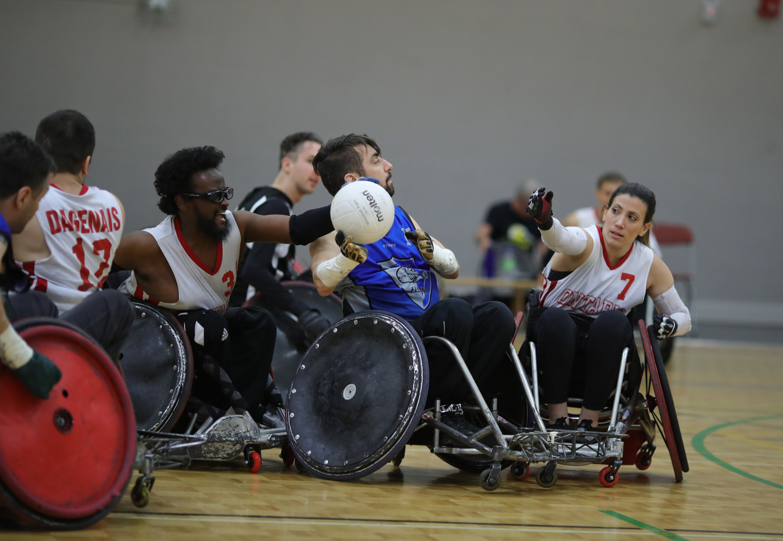 Mélanie Labelle et l'un de ses collègues essaie d'intercepter le ballon au rugby en fauteuil roulant.